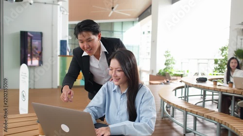 Asian Business Colleagues Celebrating Success with Laptop in Bright Office Canteen