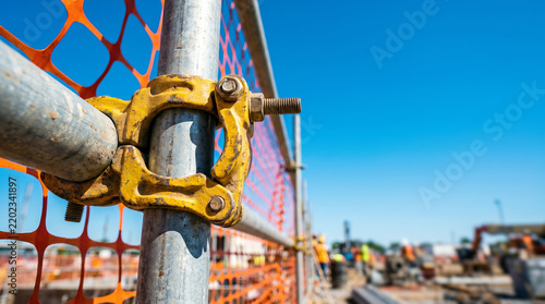 Scaffolding pipes with coupler at construction site under blue sky, for building development or industrial safety.
