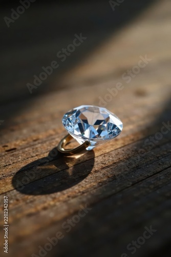 A sparkling gemstone rests on a rustic wooden surface, bathed in sunlight, casting a captivating shadow
