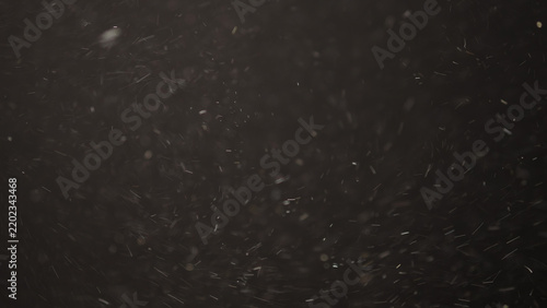 Slow motion real dust flow over dark background