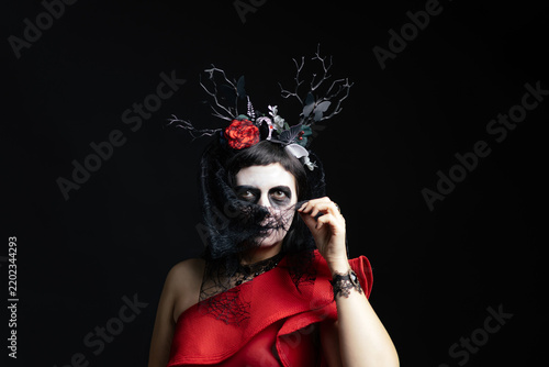Canvastavla Day of the Dead or Halloween themed image with a woman with skull painting on her face and a skull