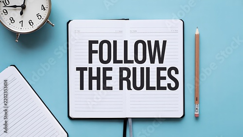 Follow the rules concept with notebook, pencil, clock and office workspace representing compliance and workplace guidelines
