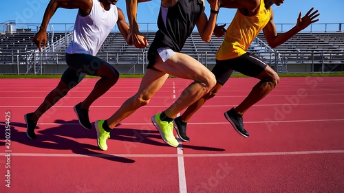 Athletes running on a track during a competitive race in an outdoor stadium