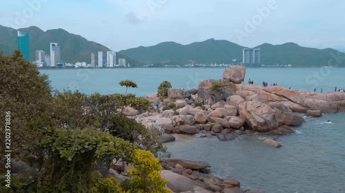 Hon Chong Promontory, a scenic spot in Nha Trang, Vietnam features unique, massive rock formations and a small beach, offering coastal views of the city with its hotel towers and hills 
