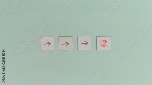Target goal and strategic planning concept with arrows and bullseye tiles on green background