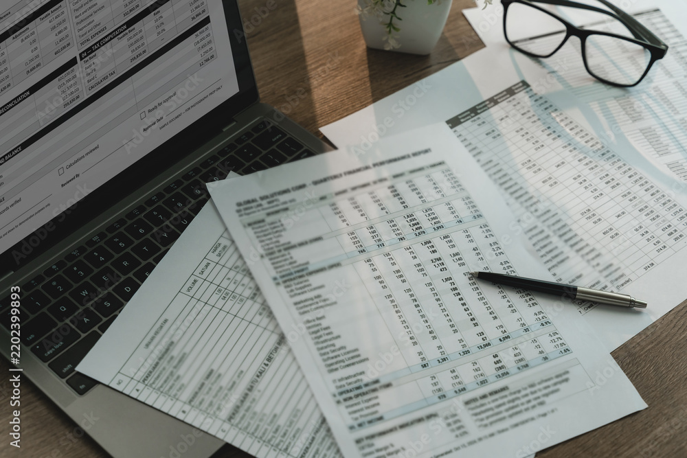 Obraz premium Accounting spreadsheets and financial reports beside laptop, calculator and pen, showing financial calculation, data review and business analysis workflow.