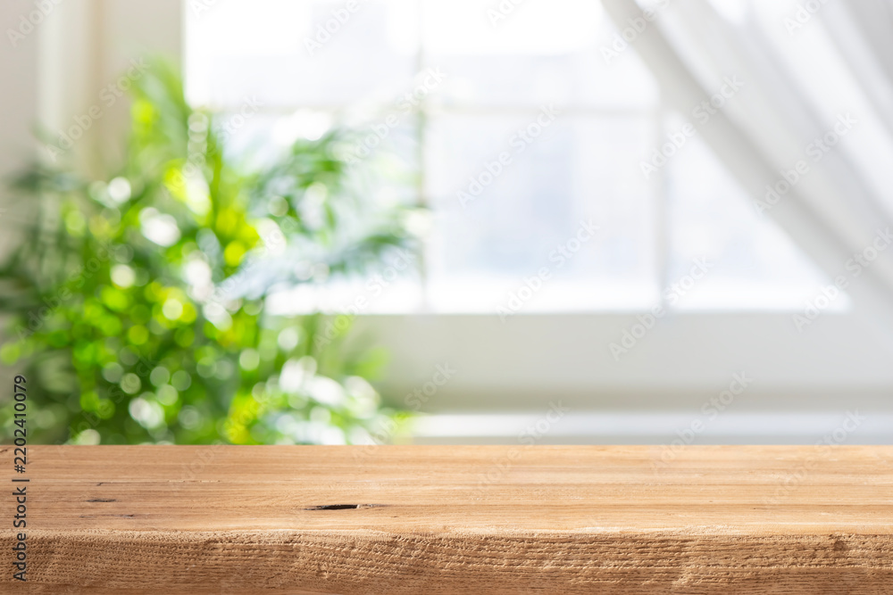 Naklejka premium Wooden table top with blurred green plant and window background