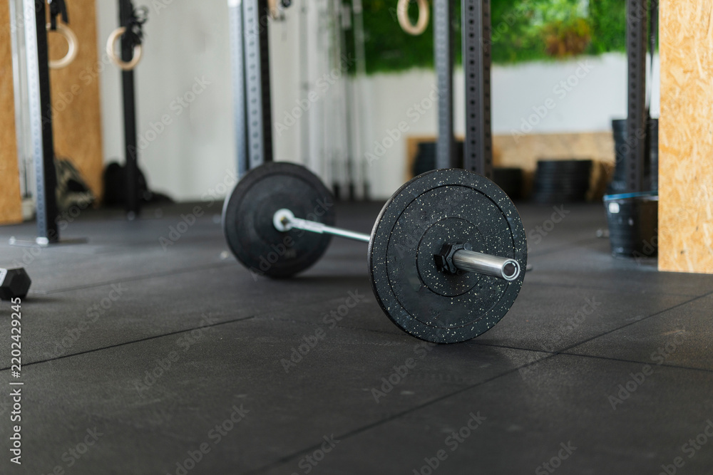 Obraz premium Barbell with weight plates on gym floor ready for workout