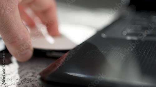 Person Inserting CD DVD Disc into Laptop Optical Drive