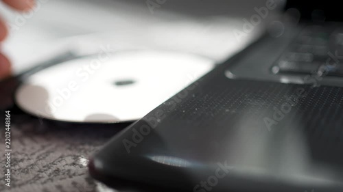 Person Inserting CD DVD Disc into Laptop Optical Drive