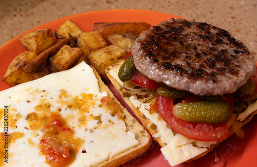 Foto Open-faced burger with grilled patty, white cheese, pickles, tomatoes, carameliz