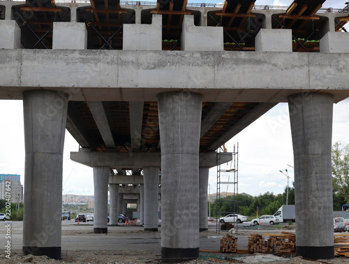 Construction of a two-level road interchange at Satpaev Avenue and Zhibek Zholy Street, with concrete flyovers and heavy equipment. Modern architecture. Ust-Kamenogorsk (Kazakhstan)