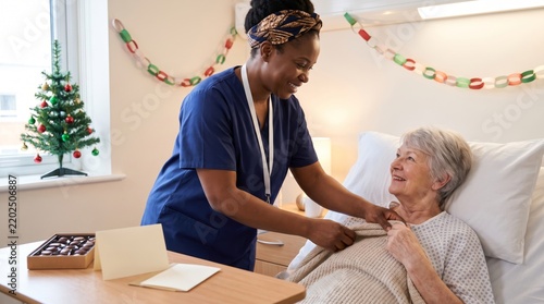 Nurse caring for an elderly patient on a hospital ward at Christmas