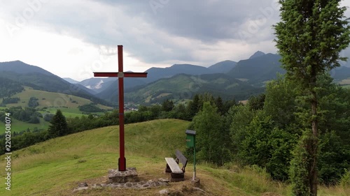 Side movement trucking shot of a wooden Christian cross on a mountain hill before storm