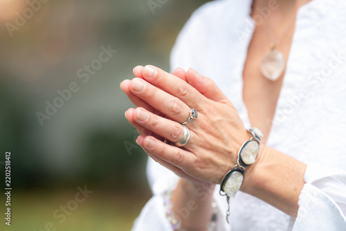 Fotografie Quietude: mindfulness coach holding hands in prayer gesture outdoors, expressing stillness, inner calm, seclusion and peaceful spiritual awareness