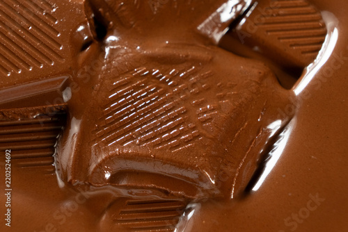 Foto Close up of milk chocolate chunks melting with glossy dripping texture