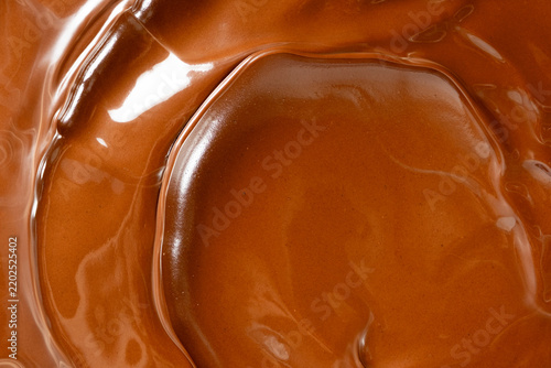 Glossy melted chocolate waves abstract background vertical macro shot