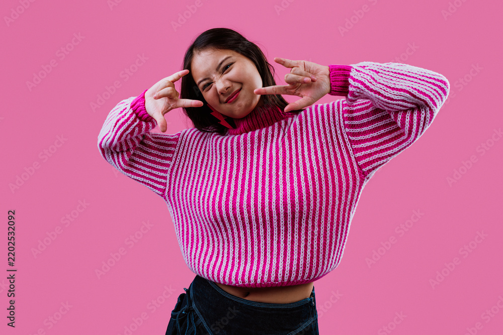 Obraz premium Young woman showing rock n roll gesture smiling