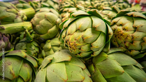 View of fresh green artichokes stacked in a market display in California City, California, United States.