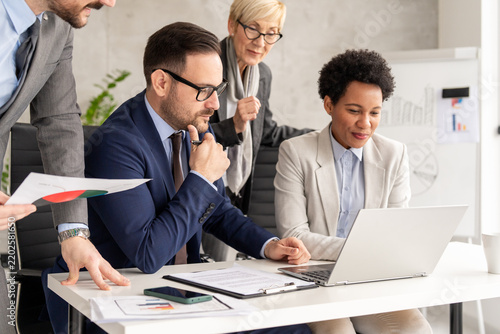  Multiethnic multinational business team working together around office table