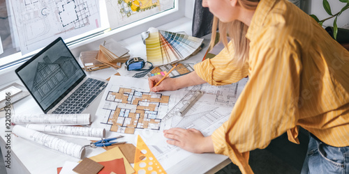 architect Eco retrofit planning with blueprints, material swatches and finish samples, sustainable renovation budget and healthy material selection concept for honest architectural design.
