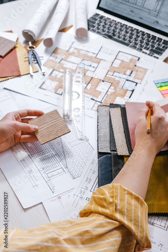 architect Eco retrofit planning with blueprints, material swatches and finish samples, sustainable renovation budget and healthy material selection concept for honest architectural design.