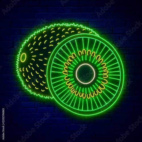 Bright green neon sign shaped like whole and sliced kiwi fruits mounted on brick wall
