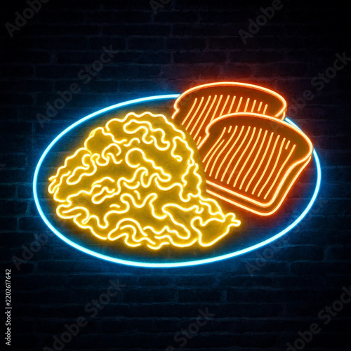 Bright neon sign depicting scrambled eggs and toast on a plate mounted on a dark brick wall