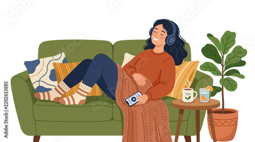 Woman relaxing on sofa listening to music with headphones