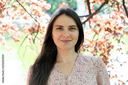 Happy adult female looking at camera outdoors, copy space for text