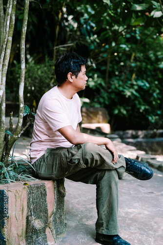 Man Sitting Outdoors in Lush Green Tropical Park