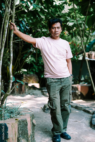 Man Standing Outdoors in a Lush Green Forest Environment