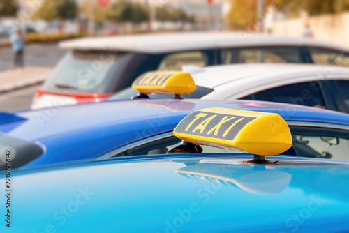 Obraz na plátně taxi cabs with yellow roof signs waiting for passengers in an urban street durin