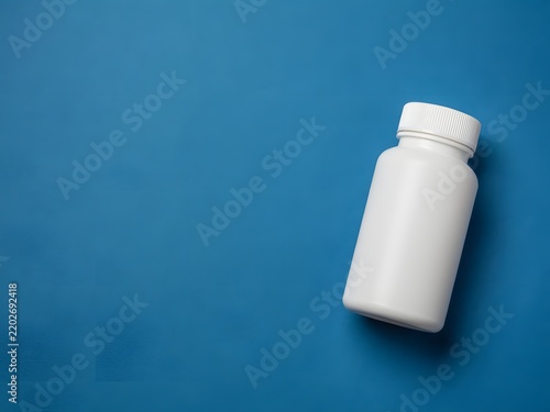 White plastic pill bottle with child-resistant cap on blue background