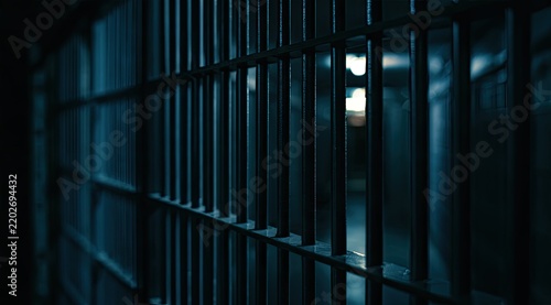 Stark prison bars casting long shadows in a dimly lit, desolate hallway