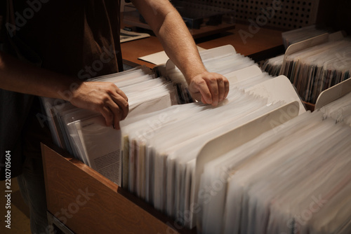 Foto Slow living and digital detox through vinyl collecting, hands sorting records in store as mindful analog hobby and screen-free leisure