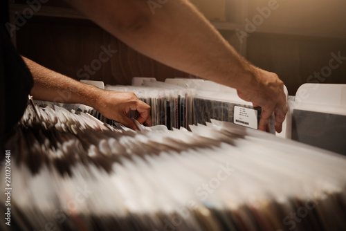 Fotografie Tactile vinyl discovery in record store as hands browse physical albums during slow living, retro aesthetic, analog hobby and offline leisure