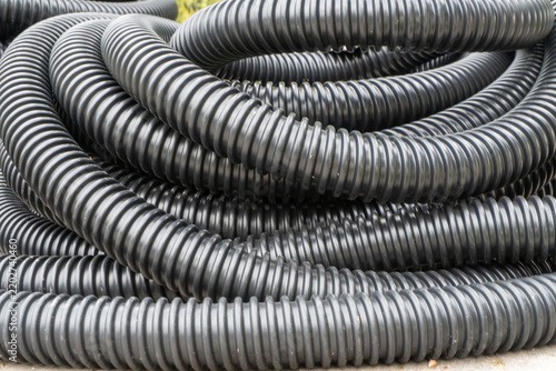 Black plastic tubing coiled on outdoor ground