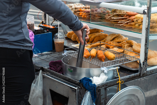 Street vendor preparing fried snacks in urban setting