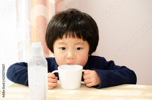 飲み薬を飲む子供