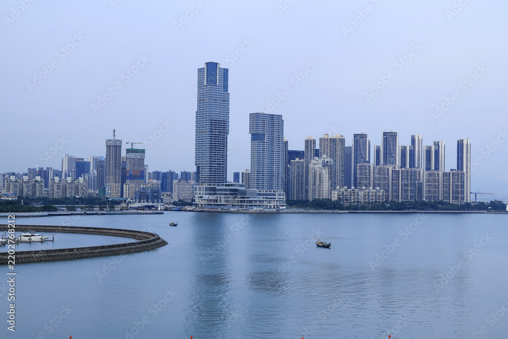 Fototapeta premium Modern Waterfront Skyline with High-Rise Towers and Calm Water