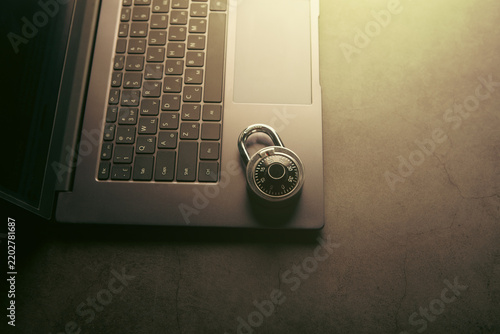 Laptop and padlock on dark background. Security and safety concept.