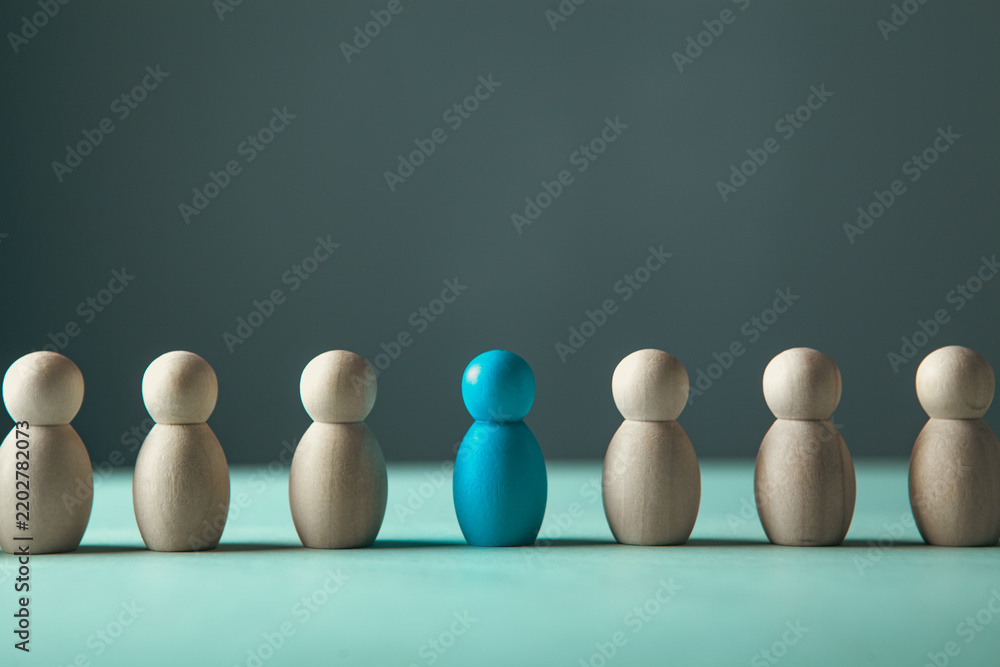 Obraz premium Leadership concept. Group of white wooden people standing in a row and one blue leader