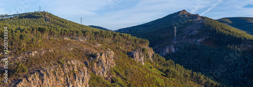 A wide panoramic view captures rugged mountain ridges and rolling forested hills