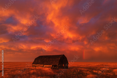 Old barn at Sunset with Rainbow and storm clouds in eva oklahoma