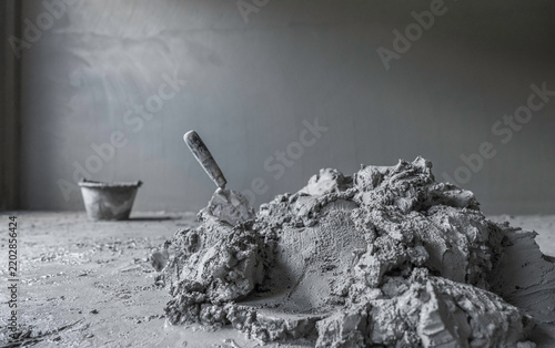 Mortar Cement mix with rough on construction concrete floor and trowel mixing prepare plaster concrete Portland wall room house site background and bucket with space blank for design text presentation
