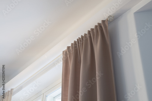Принти на полотні Elegant beige curtain hanging on a sleek metal rod near a bright window