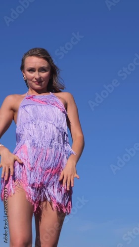 Vertical Young Woman in Fringe Dress Dancing and Walking Along the Riverside on a Beautiful Summer Day
