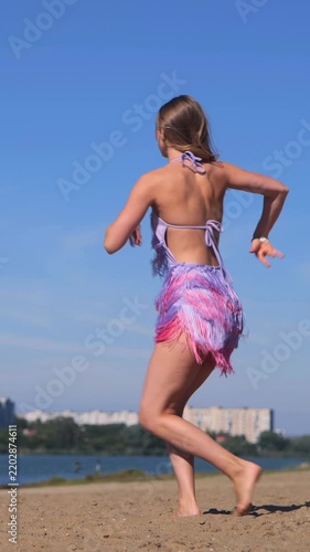 Vertical Beautiful Young Woman in Purple Summer Dress Relaxing and Dancing Outdoors by the Riverside
