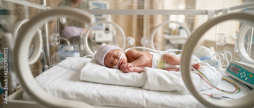 Premature newborn baby girl resting peacefully, representing neonatal care, early birth, infant health, medical support and the delicate first days of life.